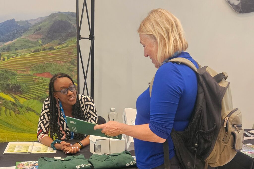 A woman reading a brochure at the G20 Land Restoration Initiative stand at the 14th European Conference on Ecological Restoration.