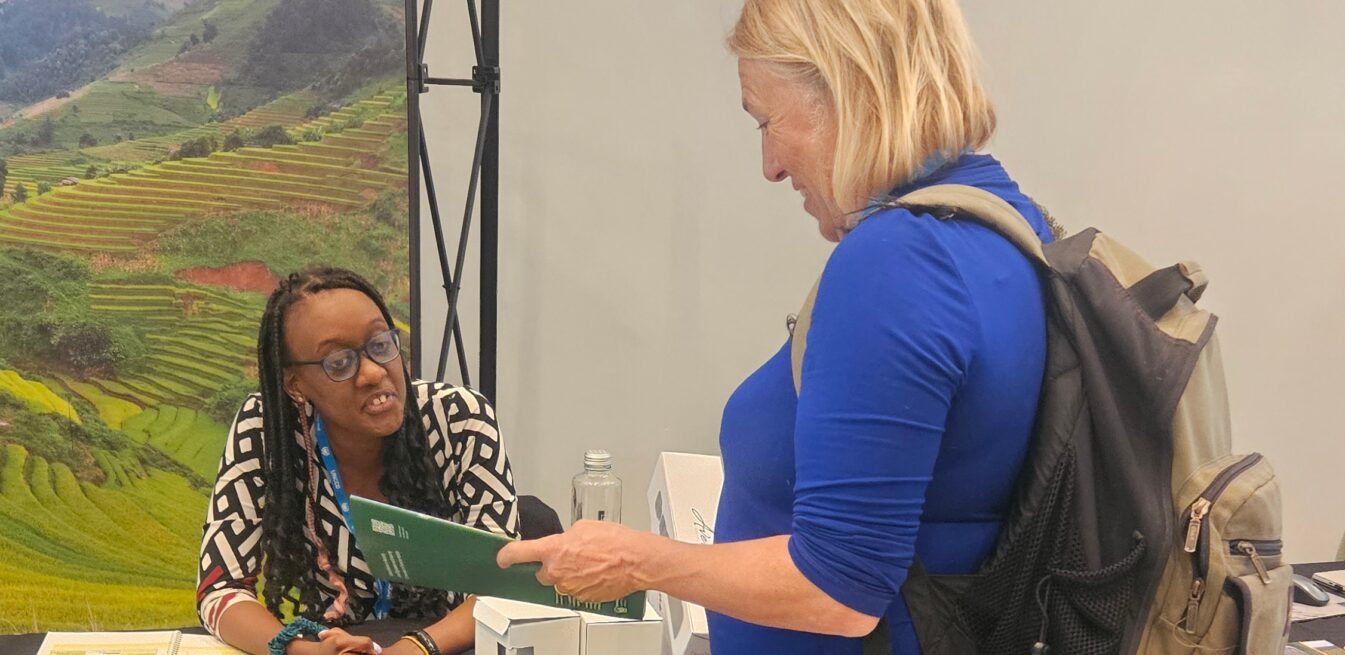 A woman reading a brochure at the G20 Land Restoration Initiative stand at the 14th European Conference on Ecological Restoration.