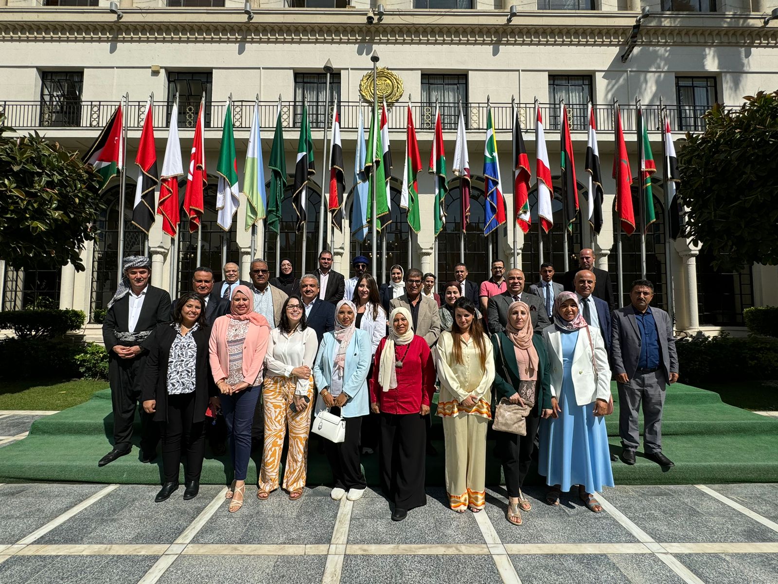 Participants at the Biosaline Agriculture as an approach to land restoration in the Arab world, in Cairo, Egypt, pose in front of flags