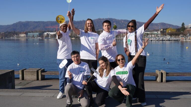 Group of young men and women holding signs and raising hands by Lake Zurich in Switzerland