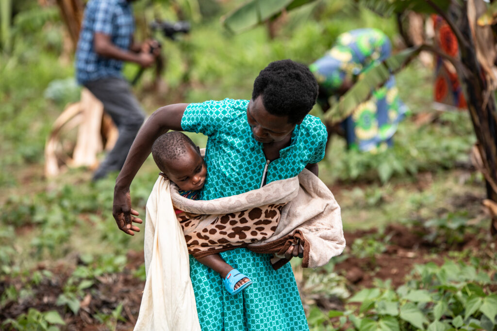 A woman with her baby around waist, carrying, in Rwanda