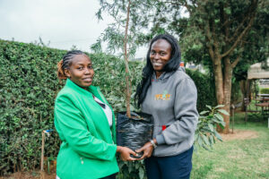 Two women holding a tree sapling in Kenya