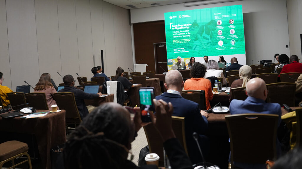 A room filled with event participants before panelists