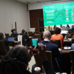 A room filled with event participants before panelists