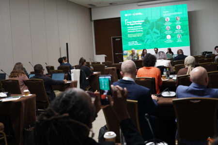 A room filled with event participants before panelists