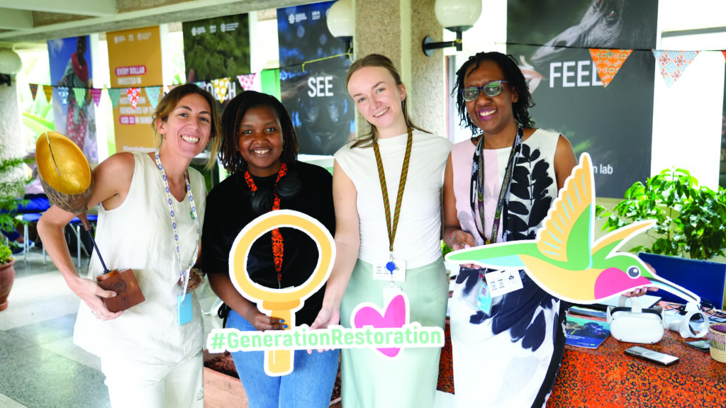 Four women holding signs for social media campaign