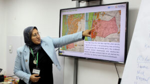 Woman pointing at a map on screen