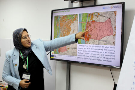 Woman pointing at a map on screen